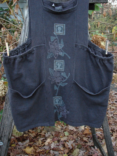 1995 Reprocessed Cottage Jumper Floral Vine Granite Size 3 hanging on a clothesline, showcasing its playful floral vine pattern, thick shoulder straps, sectional bib, elastic sides, and two oversized front pockets.