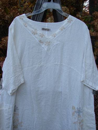 Barclay Linen Cross Over Dress with flower design on a white shirt.