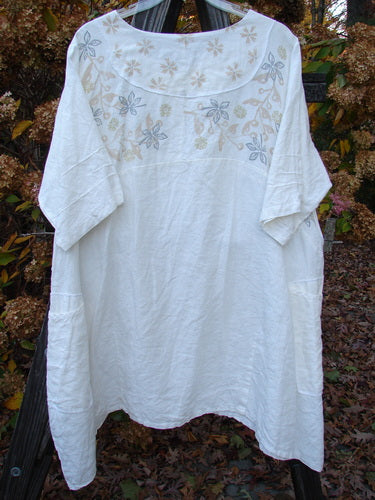 Barclay Linen Cross Over Dress with floral design, person's arm, outdoor pattern, sleeve textile details.
