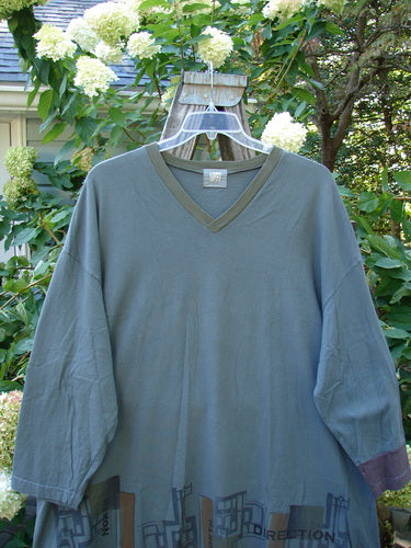 V Neck Grid Top from 2000 Collection, featuring a V neckline, long sleeves, single cuff, and an A-line shape, displayed on a hanger.