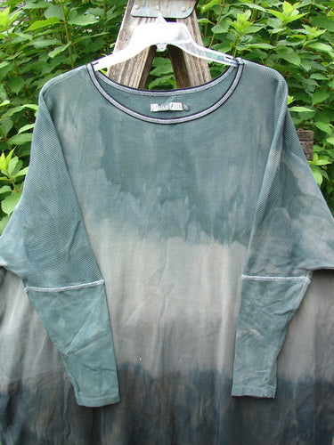 Barclay Thermal Contrast Revival Top Unpainted Mottled Sage Shade OSFA displayed on a clothes rack, highlighting its ribbed sleeves and neckline, rounded A-line shape, and side vents.