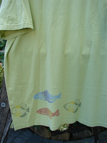 2000 Short Sleeved Tee Fish School Key Lime Pie Size 2 featuring fish designs, drop shoulders, wide sleeves, and a generous shape and length. Made from medium-weight organic cotton, perfect condition.