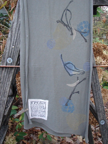 1994 Scarf Forest Leaf Raku One Size draped on a wooden ladder, featuring a subtle bird design, showcasing the vintage and artistic aesthetic of BlueFishFinder’s unique collection.