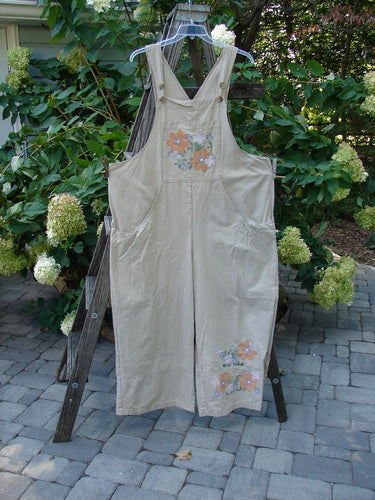 2000 Parachute Overall Pant Jumper Floral Dove Size 2 displayed on a wooden ladder, showcasing painted front bib pocket, deep side pockets, and adjustable shoulder straps with metal buttons.