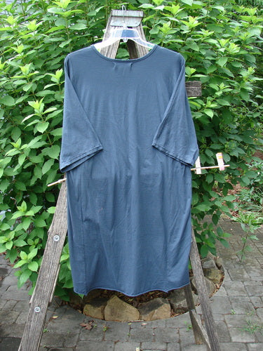 Barclay NWT Tournesol Slim Tunic Turn Moon Navy OSFA displayed on a wooden ladder, showcasing its drop shoulders, loose three-quarter sleeves, and unique varying hemline.