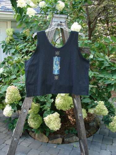 1997 Elements Crop Tank Wave Curl Ebony Size 2, displayed on a wooden ladder, featuring a scooped neckline, deeper arm openings, and a bright contrasting fish patch.