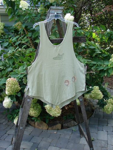 2001 Katy Vest Circle Rain Kelp Size 1 displayed on a wooden ladder, showcasing its organic cotton fabric, unique varying hemline, triangular pockets, and blue button closures.