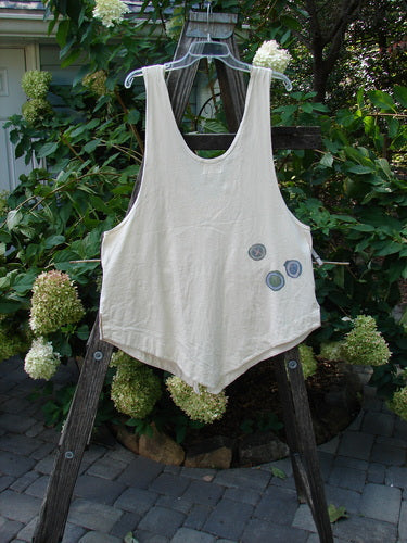 2001 Katy Vest Chain Rain Natural Size 1 displayed on a wooden ladder, featuring lengthy thin shoulder straps, a swingy lower hem, triangular pockets, and two textured blue buttons.