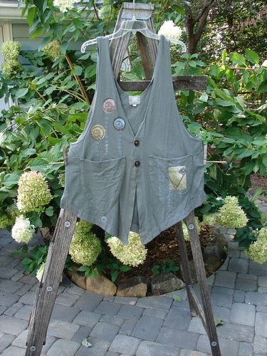 2001 Katy Vest Shell Rain Inkpod Size 1 displayed on a wooden ladder, featuring two front triangular pockets, vented sides, and two textured button closures.