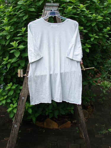 Barclay NWT Slub Simple A Line Tee Feather Dew Size 2 displayed on a wooden stand, showcasing its three-quarter length sleeves, rounded neckline, slight A-line flare, and curly edgings.