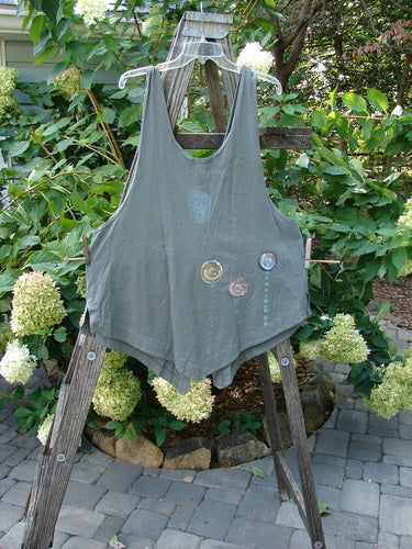 2001 Katy Vest Shell Rain Inkpod Size 1 displayed on a wooden ladder, featuring lengthy thinner shoulder straps, a wider rounded A-line shape, two front triangular pockets, and varying hemline.