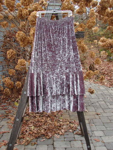 Barclay Velvet Two Story Dance Skirt Unpainted Rosewater Size 2: A flouncy purple velvet skirt with two tiers, elegantly draped on a wooden ladder.