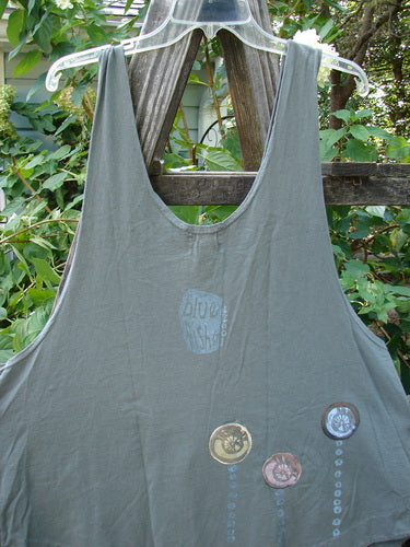 2001 Katy Vest Shell Rain Inkpod Size 1 displayed on a wooden fence, highlighting its organic cotton fabric, unique A-line shape, and two front triangular pockets with textured blue fish button closures.