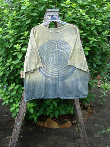 Barclay Wide Line Tee Primitive Circle Path Mottled Olive Grey OSFA with drop shoulders, wide boxy shape, seamless design, featured outdoors on a swinger, highlighting its unique style and generous dimensions.