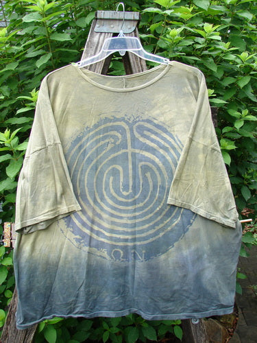Barclay Wide Line Tee Primitive Circle Path Mottled Olive Grey OSFA, showcasing a seamless, boxy shape with significant drop shoulders and a rounded, slightly ribbed neckline, highlighted in an artistic outdoor setting.