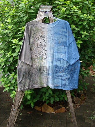 Barclay Wide Line Tee Wind Fish Mottled Navy Gray OSFA displayed on a wooden ladder, showcasing its seamless, boxy shape and rounded, slightly ribbed neckline, emphasizing its unique design and drop shoulders.