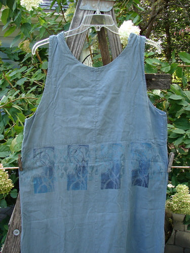 2000 Almost 7 Jumper Rock Wall Blue Mineral Size 1 hanging on a clothesline, showcasing button shoulders, rounded neckline, yoked waist seam, and unique tabbed sides at the hem.