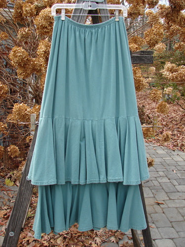 1993 Two Story Skirt, teal, size 2, made of double-layered cotton jersey. Elastic waistline, flouncy tears, wide weighted lower sweep. Triple layered look with flouncy upper piece. Waist 26-42, hips 48. Length 38".