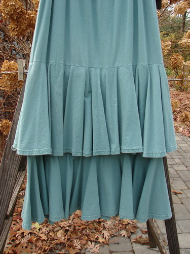 1993 Two Story Skirt on rack, teal, size 2. Double layered cotton jersey, elastic waistline, flouncy tears, wide weighted sweep. Triple layered look for classic fish style.