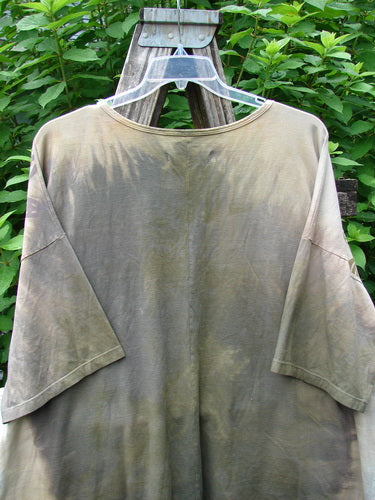 Barclay NWT Center Seam Wide Line Tee Earth & Sea Mottled Lens OSFA displayed outdoors on a hanger, showcasing its rounded neckline, drop shoulders, and distinctive vertical center seam, emphasizing its wide, boxy shape.