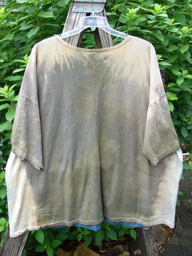 Barclay NWT Center Seam Wide Line Tee Earth & Sea Mottled Lens OSFA displayed on a clothes rack, showcasing its wide, boxy shape, drop shoulders, and distinctive center seam in an organic cotton fabric.