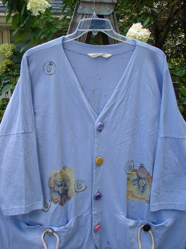 1997 Day Jacket Curl Wind Freesia OSFA featuring brightly colored vintage buttons, dolman sleeves, V neckline, and front rounded tails, displayed on a hanger.