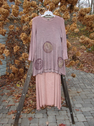 1999 Acetate Lycra Camillia Duo Swan Size 1 2: A pink dress on a wooden stand with a purple dress featuring a bird design on it, and a pink cloth on a ladder.