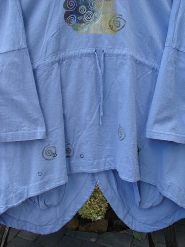 Close-up of the 1997 Day Jacket Curl Wind Freesia OSFA, featuring vintage buttons, front drop pockets, dolman sleeves, V neckline, drop shoulders, rounded tails, and an upward scooped back hemline with draw cord.