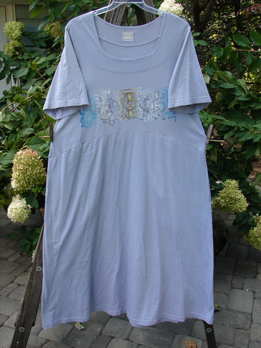 1999 Windmill Dress Turn Wind Lilac Size 2 displayed on a clothesline, showcasing its sweeping A-line shape, squared double-paneled neckline, and flared hemline with graceful movement and bottom swing.