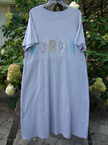 1999 Windmill Dress Turn Wind Lilac Size 2 hanging on a clothesline, showcasing its flattering A-lined shape, squared neckline, flared hemline, and two side pockets.