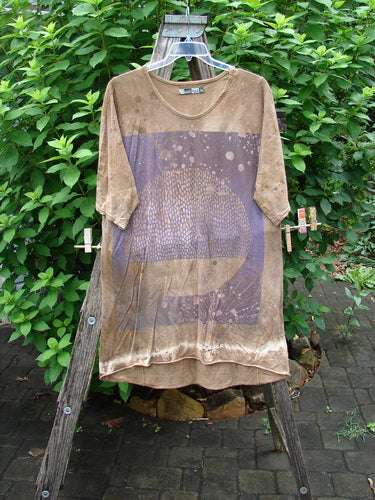 Barclay Tournesol Slim Tunic Moon Rise Mottled Earth OSFA displayed on a wooden stand, features a mid-length design with drop shoulders, loose three-quarter sleeves, and a varying hemline.