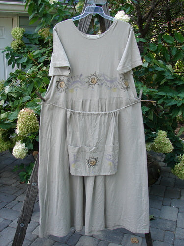 1997 Lawn Dress Star Path Wheat Size 2 on a clothesline, featuring a detachable apron with three pockets, tailored pleats, drop waistline, and signature Blue Fish patch.