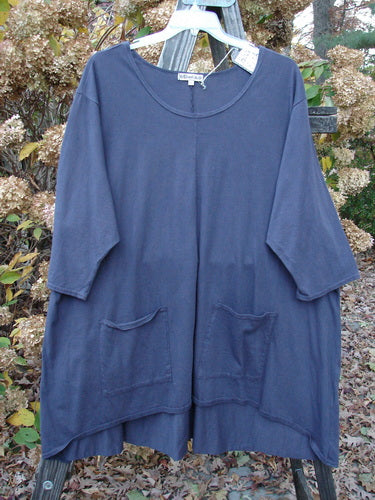 Barclay NWT Hi Low Pocket Tunic Top on a clothes rack. A-line shape with double lower front pockets and three-quarter length sleeves.