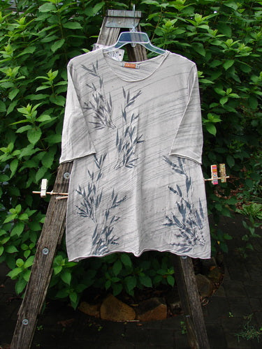 Barclay NWT Viscose Horizon Raw Cut Tee Wheat Field Vintage Quartz Striation Size 1, featuring a raw cut neckline and three-quarter sleeves, displayed outdoors on a hanger, emphasizing its lightweight organic cotton blend.