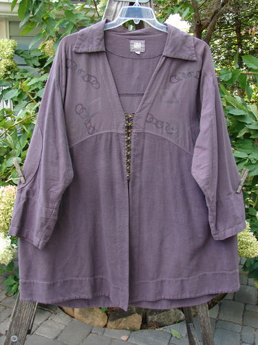 2000 Flannel Fanne Shirt Bubbles Eggplant Size 2 on a wooden hanger, featuring a deep V-neck, contrasting flannel and canvas pattern, elbow accents, and a rounded hemline.