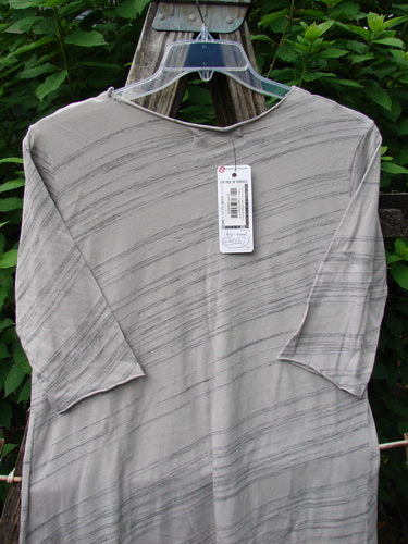 Barclay NWT Viscose Horizon Raw Cut Tee Wheat Field Vintage Quartz Striation Size 1 displayed on a swinger, showcasing its raw cut neckline, three-quarter sleeves, and A-line shape.