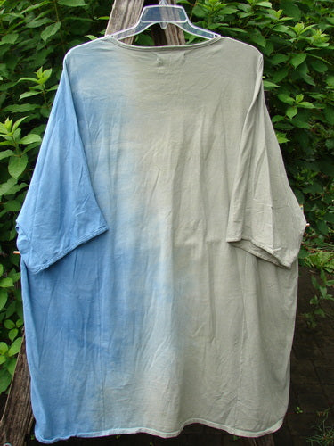 Barclay Art Tee Double Moon Blossom Mottled Blue Dusk OSFA on a clothes rack, featuring a longer tunic length, drop shoulders, loose three-quarter sleeves, and a unique upward rounded front hem.