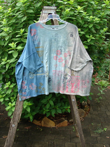 Barclay Dolman Curl Edge Square Pullover Play Dress Up Mottled Blue Day OSFA displayed on a wooden ladder, highlighting its seamless design, rounded neckline, and distinctive drop shoulders.