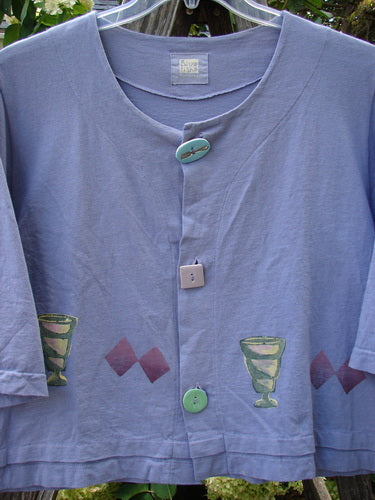 Close-up of the 1999 Tuck Top Diamond Life Iris Size 2, showcasing its double-layered organic cotton fabric, crop box shape, and three pastel glazed porcelain buttons.