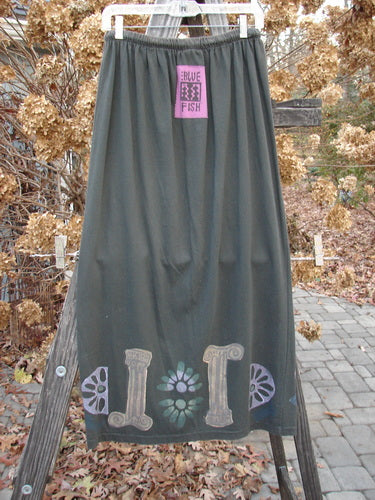 1993 Drawcord Skirt Column Black Sand Size 2: A long skirt with a pink sign on it, featuring a grey skirt close-up, a flower close-up, and a logo close-up.