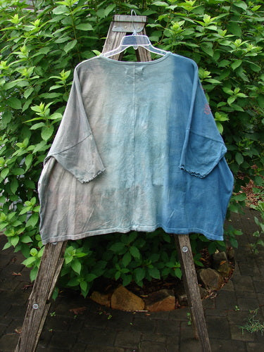 Barclay Dolman Curl Edge Square Pullover Play Dress Up Mottled Blue Day OSFA on a wooden ladder, showcasing its seamless boxy shape, rounded neckline, and distinctive curly arm edgings, reflecting BlueFishFinder's vintage aesthetic.