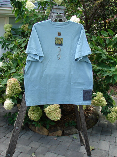 1994 Short Sleeved Tee Cricket Time Ice Size 2 XL displayed on a clothes rack, featuring a clock and rocket design, with a square box shape and drop shoulders.