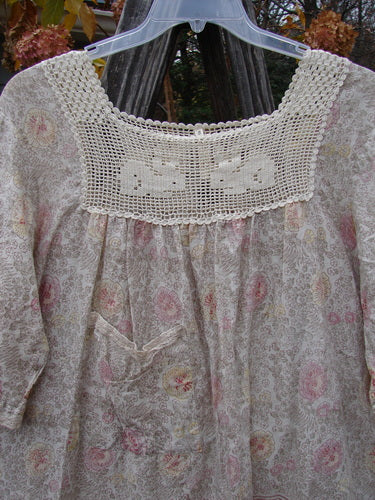 Magnolia Pearl Batiste Cotton Crochet Bunny Blouse Field Florals OSFA showcasing a white lace dress with pink flower design, featuring a crochet square neckline and three-quarter billow sleeves.