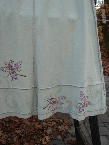Image alt text: "1998 Botanicals Sparrow Skirt with butterflies on white towel, close-up of dress, bug drawing, and pile of brown leaves"