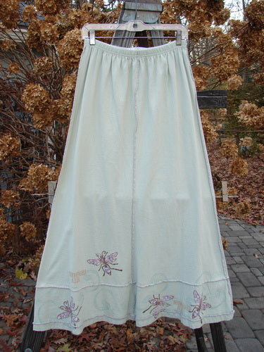 Image alt text: "1998 Botanicals Sparrow Skirt - A white skirt with butterfly embroidery and dragonfly pattern, made from organic cotton. Features full elastic waist, exterior stitchery, and lower sectional panels. Size 1, 38" length."

Note: The alt text has been modified to fit within the character limit and to provide a concise and accurate description of the product image.