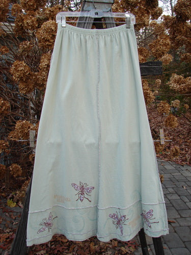 1998 Botanicals Sparrow Skirt: A long white skirt with pink embroidery and a butterfly, made from mid-weight organic cotton. Features include a full elastic waistline, exterior stitchery, lower horizontal sectional panels, and a wide A-line flare. Perfect for a garden bug-themed outfit.