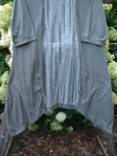 Barclay Raw Edge Flutter Drop Pocket Tunic in darkest sand, size 0, with a soft draped silhouette, raw-edge hem, and flutter sleeves. A textured center panel adds contrast to the smooth body, creating a layered, earthy look.