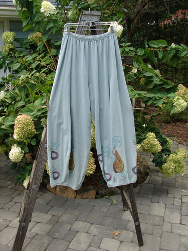 1998 Heavy Radish Pant Bountiful Harvest Birdsong Size 2 displayed on a wooden clothes rack, showcasing its elastic waistline, tapered lowers, and vertical sectional S-shaped panels.