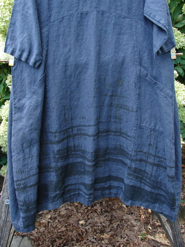 Barclay Linen Cross Over Incense Dress Structural Cliff in deep navy, size 0, with a loose linen body, short sleeves, and a softly draped crossover shape. The textured fabric shows subtle seam lines and darker horizontal banding near the hem.