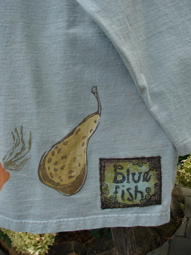 1998 Heavy Crossover V-Neck Bountiful Harvest Birdsong Size 2, featuring a close-up of a blue t-shirt with a detailed pear drawing and ribbed V-neckline.